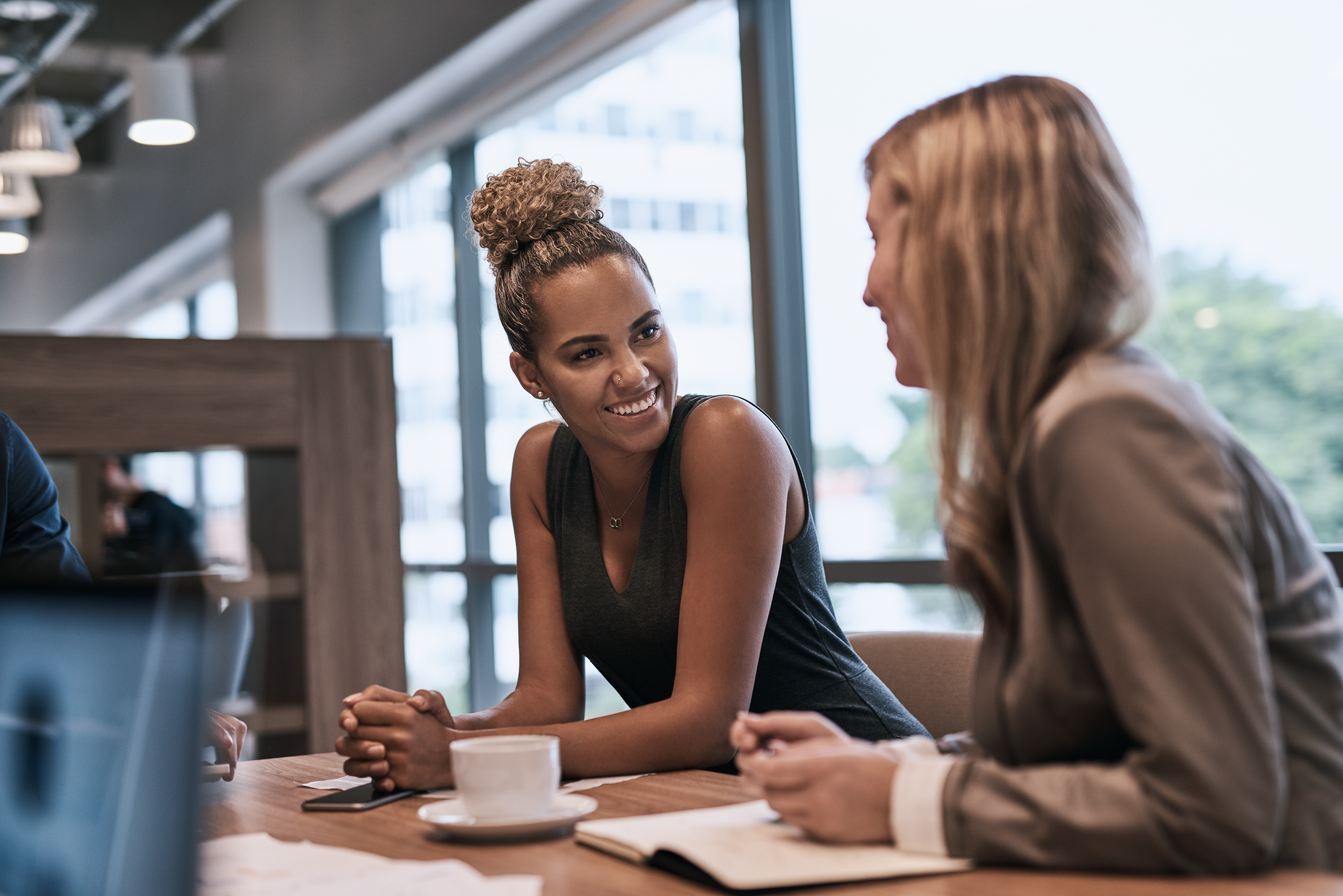 Two professionals in conversation over coffee